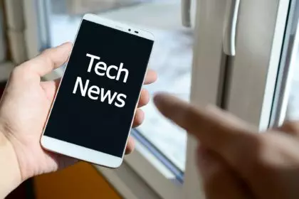 A person sees a white inscription on a black smartphone display that holds in his hand. Tech news