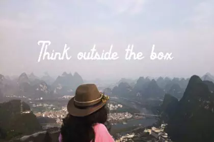 Millenial woman standing in a mountain view. Scenery. Inspirational quote.