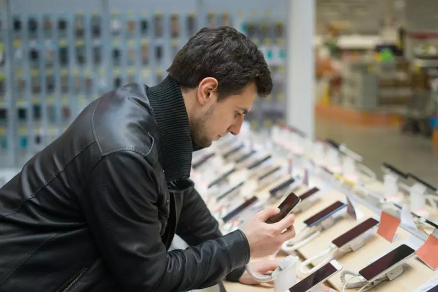 young male customer choosing smartphone