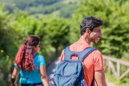 mixed race couple trekking in senda del oso, Asturias. Mid adult ecotourism in Proaza
