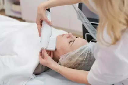 Beautician makes cute caucasian woman facial vacuum treatment for rejuvenation.