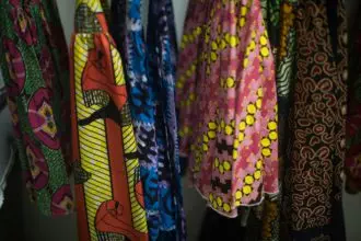 Assortment of colorful african print dresses hanging on rack