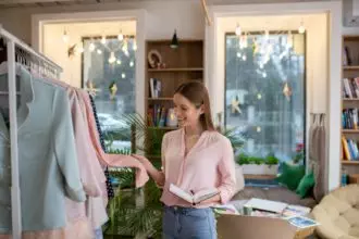 Fashion designer examining material of the pink coat