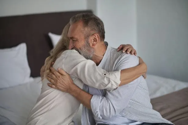 Loving husband embracing his female spouse after their reconciliation
