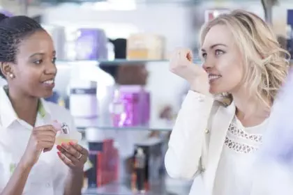 Sales woman assisting customer choosing a new perfume