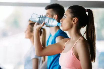 Sporty woman hydrating during workout