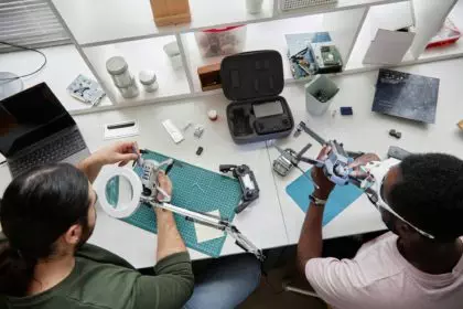 Two People Fixing Drones at Table in Tech Repair Shop