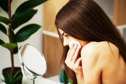 Woman in the bathroom applies cosmetics to skin care