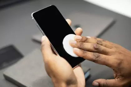 Hand of man with sanitizer for cleaning gadgets while pandemic