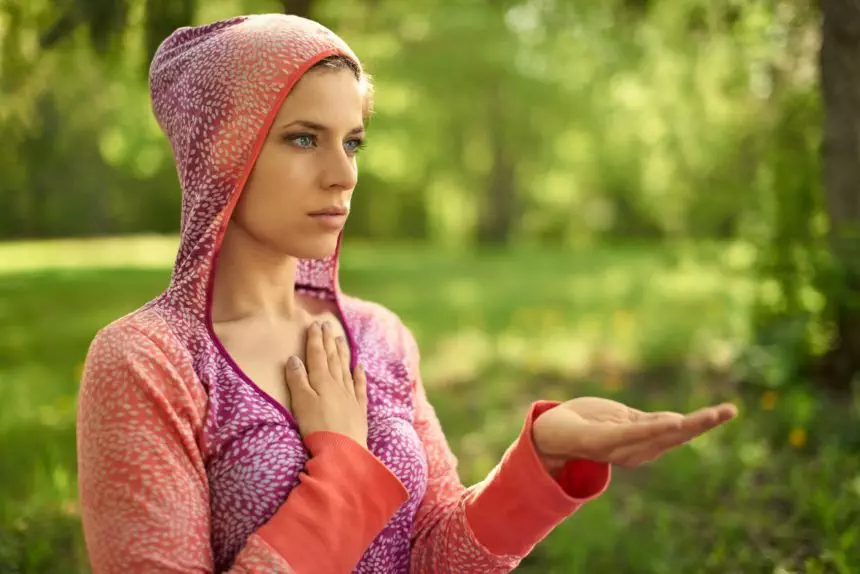 Serene and peaceful woman practicing mindful awareness mindfulness by meditating in nature at sunset