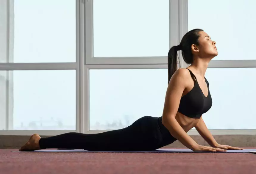 Flexible girl doing yoga pose on yoga mat.