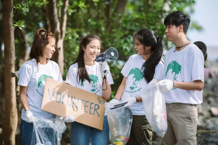 Group of volunteers hold a volunteer sign in world environment day event, volunteer conservation.