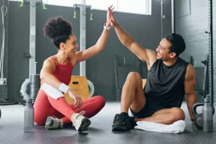 High five woman, personal trainer man for fitness goal in gym or training facility together. Succes