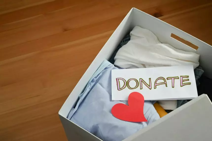 Top View Clothes Donate. Box of Cloth with Donate label. Preparing Used Old Garment at Home.
