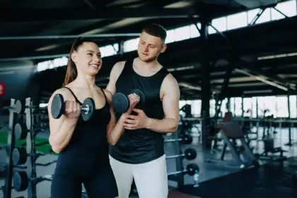 Personalized Workout Male Trainer Assists Woman in Gym Training