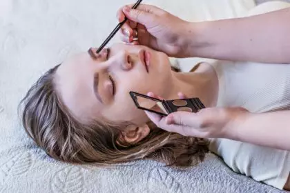 A young girl gets eyebrow correction and eye shadow coloring.Beauty and spa concept.