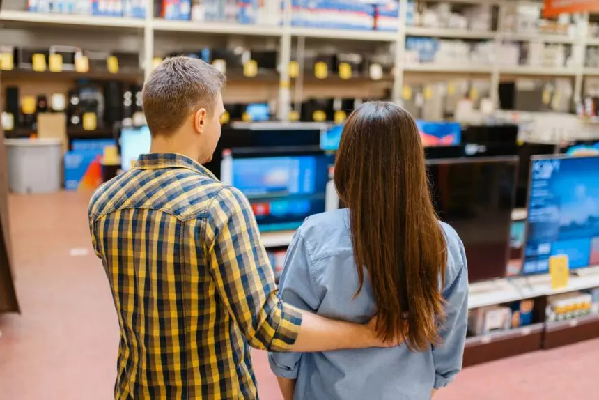 Couple choosing TV in electronics store