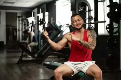 Portrait of man bodybuilder in red shirt in gym