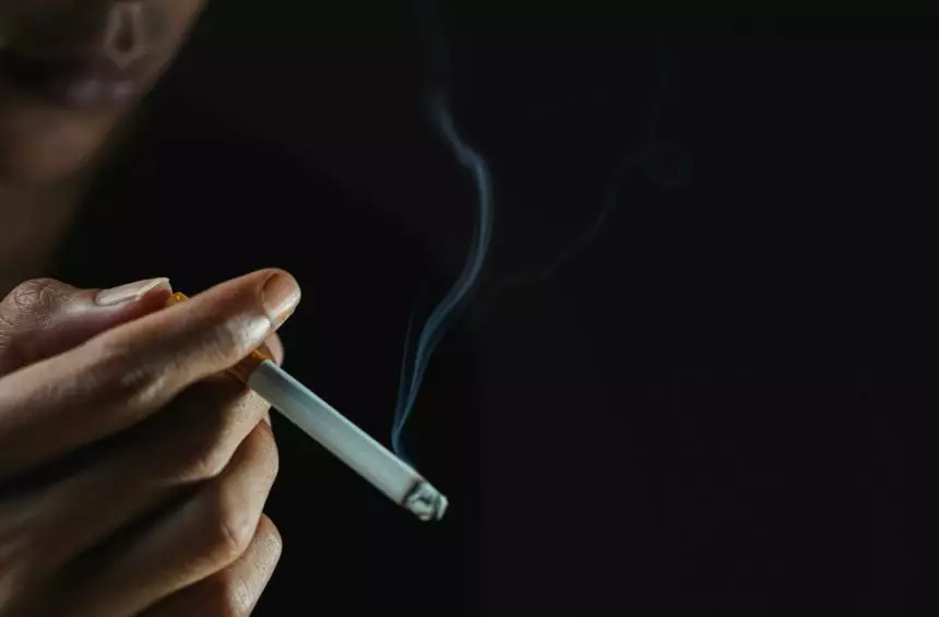 A man smoking cigarette in dark room