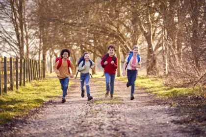 Portrait Children With School Backpacks Outdoors Running Along Countryside Track