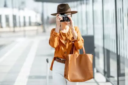 Young woman traveling with photo camera in the modern city