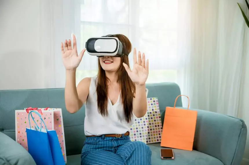 Happy young woman customer wearing 3d VR glasses virtual reality headset with shopping