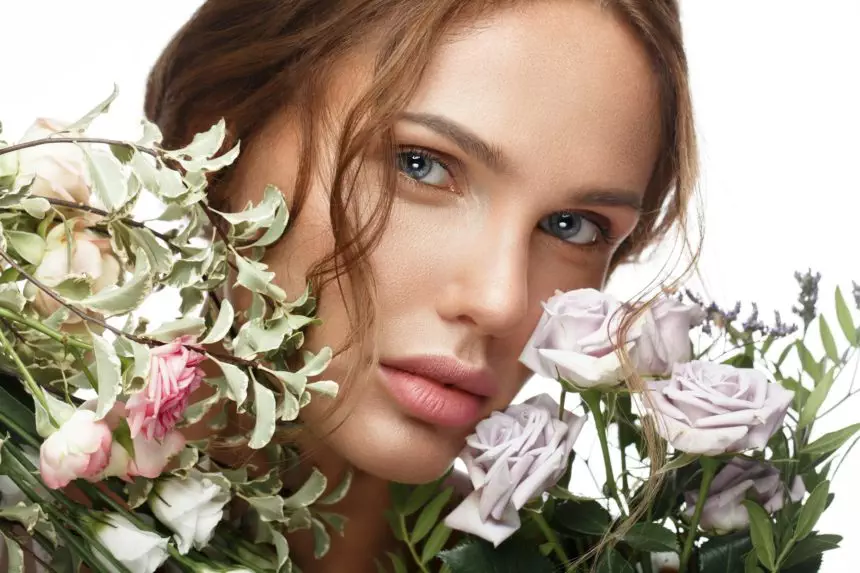 Beautiful woman with classic nude make-up, light hairstyle and flowers. Beauty face.
