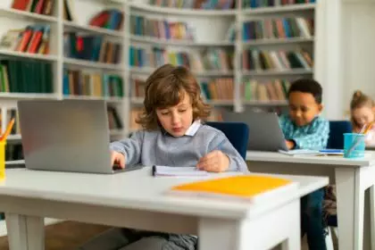 Children in class exploring education via laptops