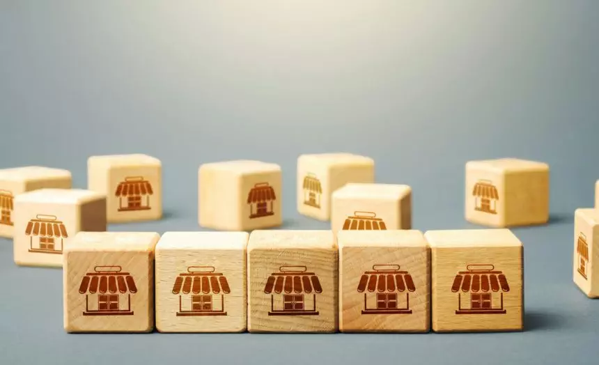 Blocks symbolizing shopping stores. Building a successful business empire. Franchise concept. Mergin