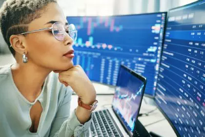 Business woman, laptop and thinking on stock market in fintech, trading or online finance at office