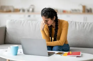 Stressed Young Indian Female Feeling Tired While Study With Laptop At Home
